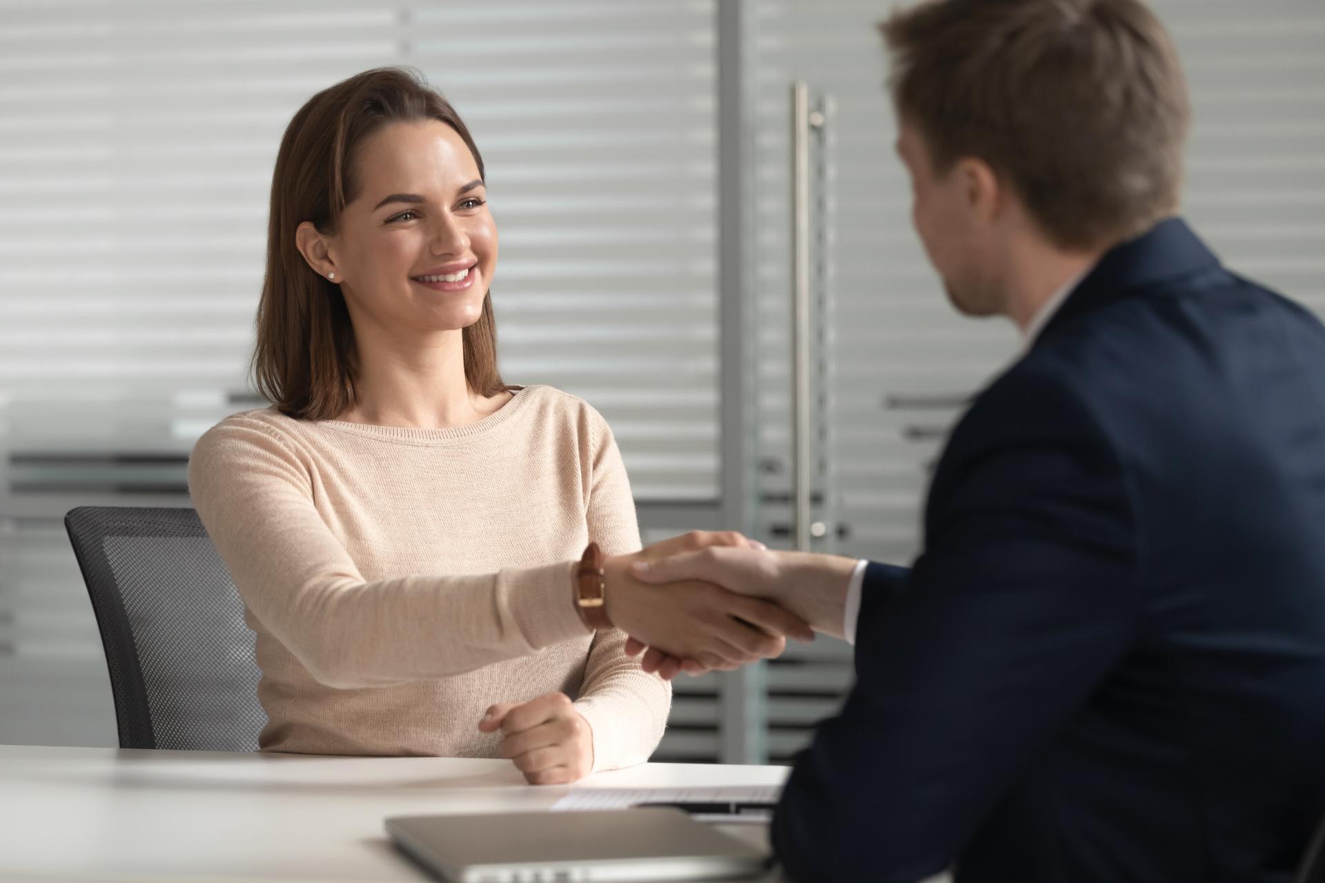 Woman shaking hands with man in a professional setting